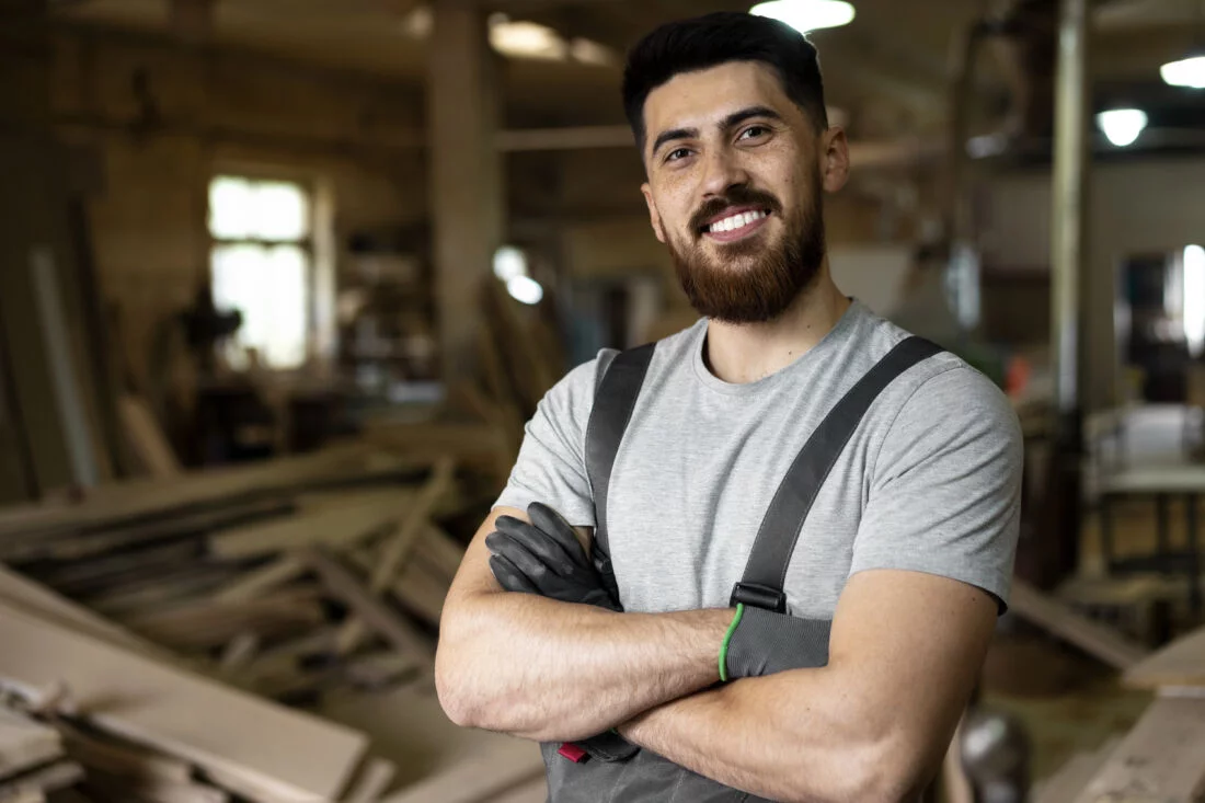 Мужчина плотник с бородой улыбается