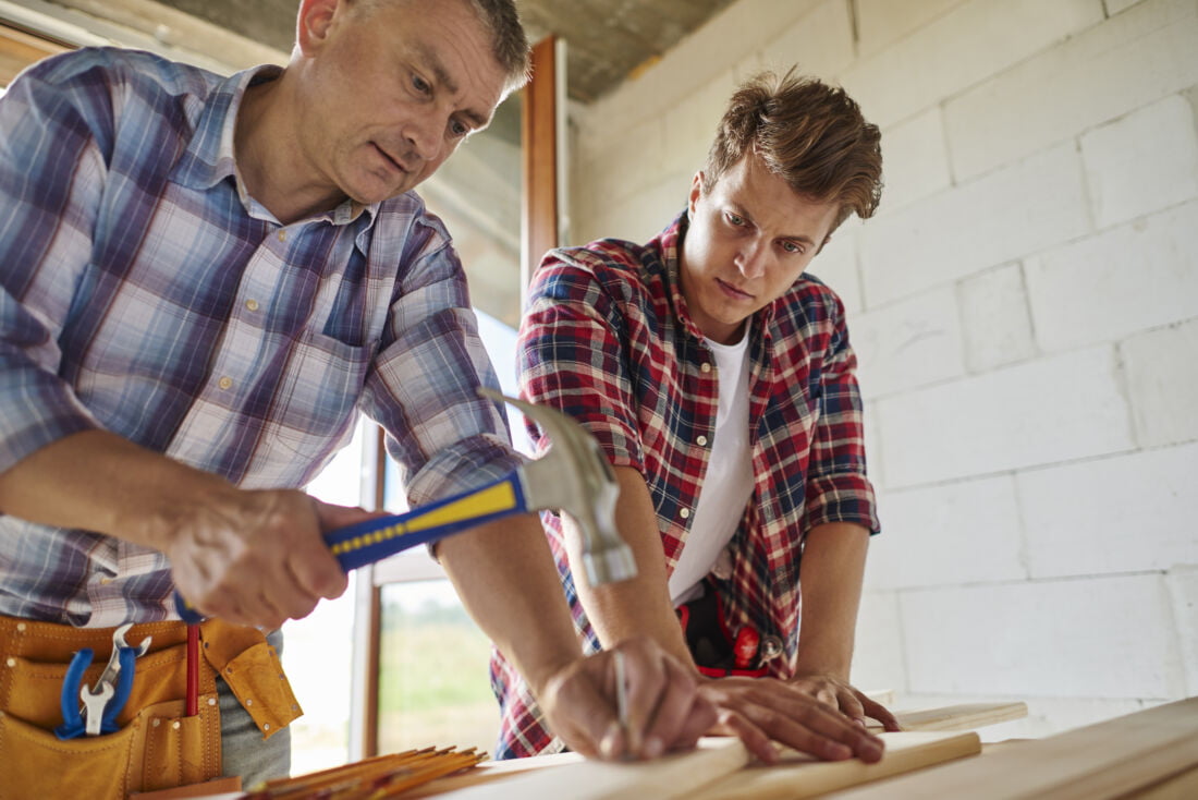 Мужчины плотники забивают гвоздь молотком Нидерланды
