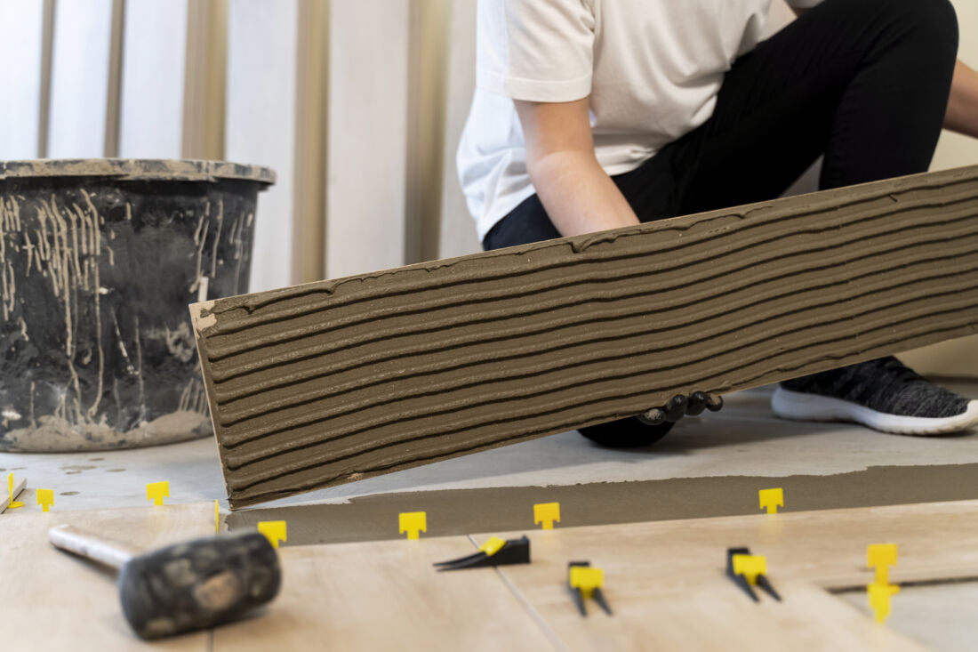 Плиточники укладывают плитку на полу