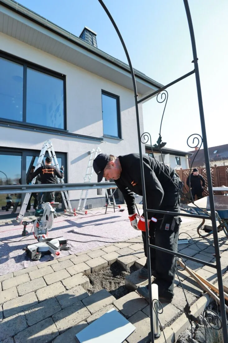 Мужчина строитель возле алюминиевой арки