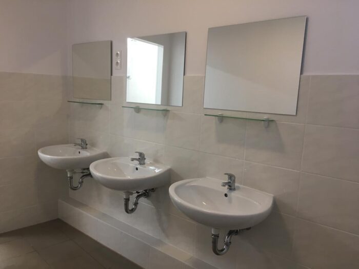 Фото трёх умывальников и зеркал в ванной комнате