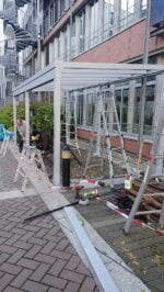 Белый каркас под навес в процессе монтажа