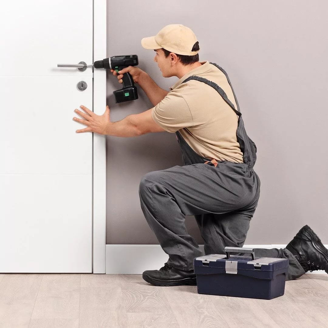 Мужчина универсал по внутренней отделке делает монтаж дверей